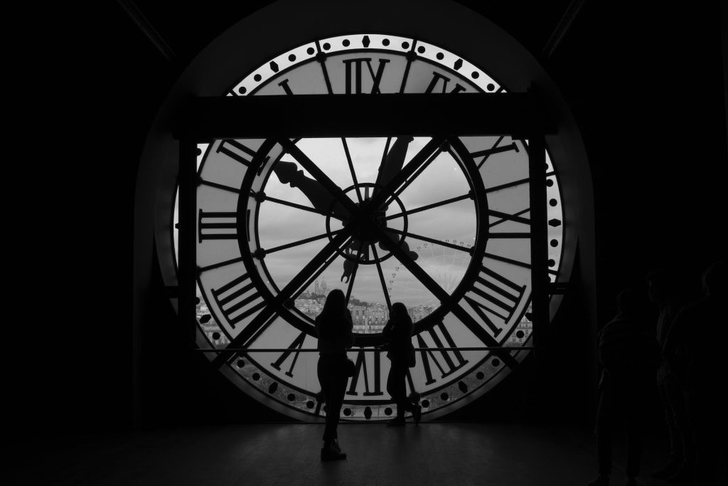 a silhouette of people standing near the clock of musee d orsay in paris france