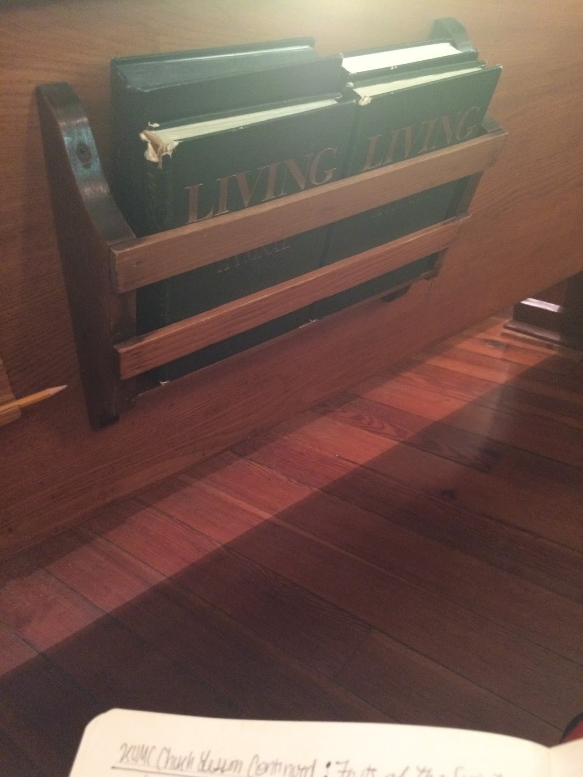 Hymnal in book holder in a church pew