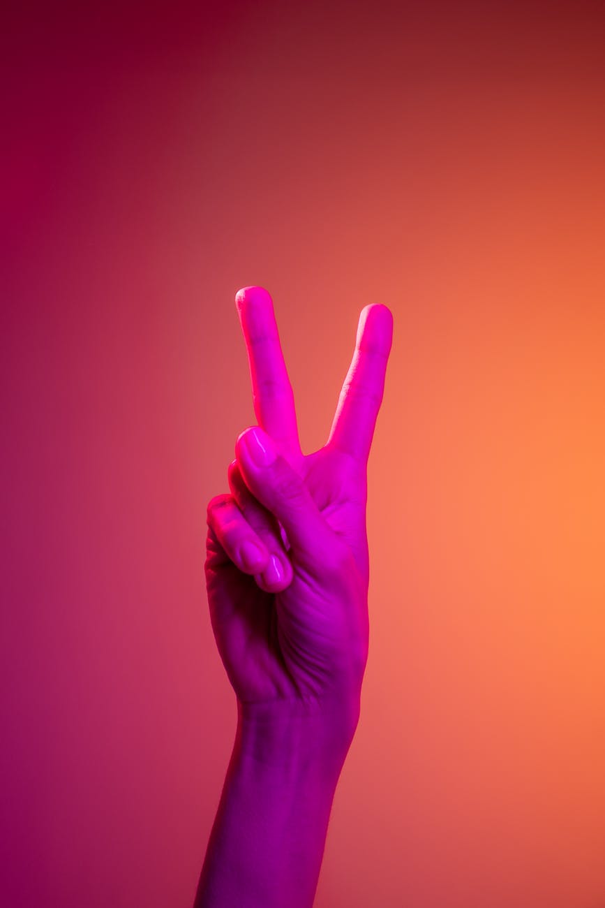 person doing peace sign hand gesture