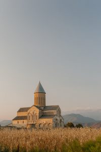 aged church in field with cereal grass