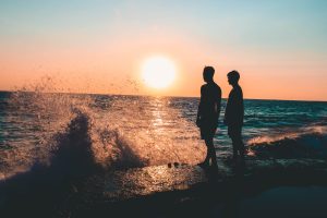 two men standing on seashore